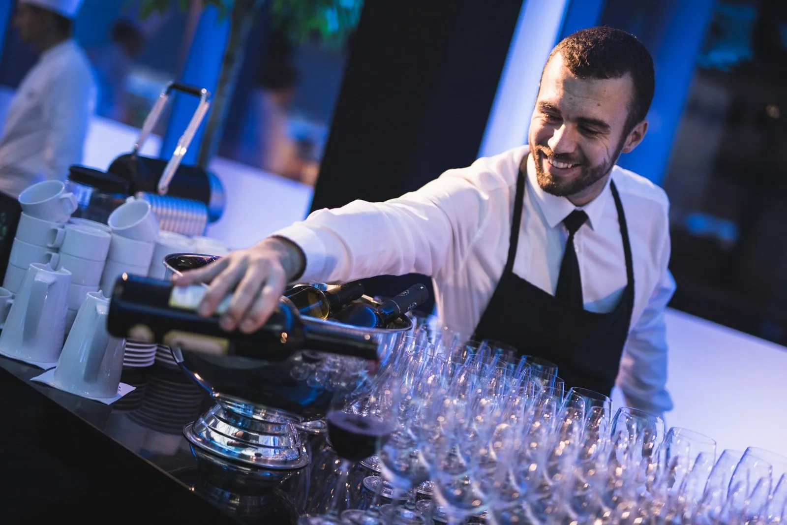 Barman připravuje sklenice před příchodem hostů