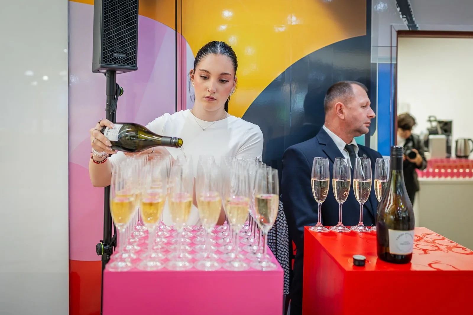 Barman připravuje barevné koktejly pro hosty