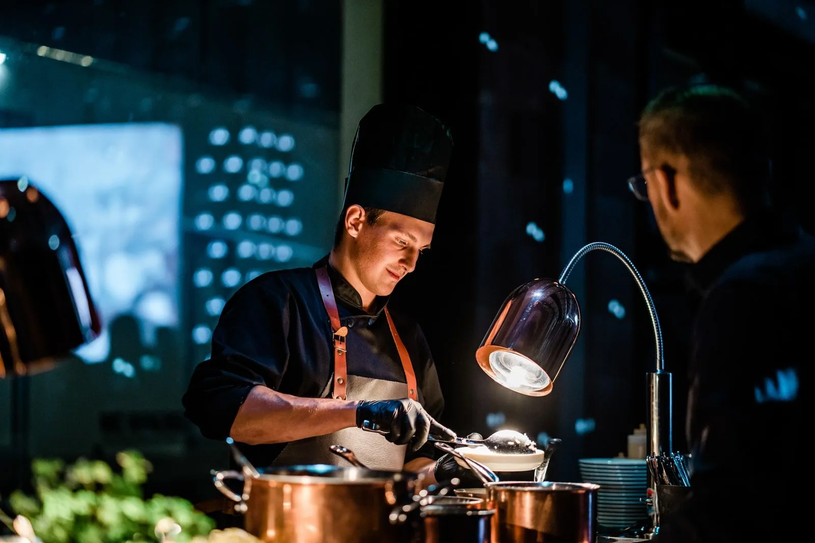 Kuchař připravuje jídlo na live cooking stanici